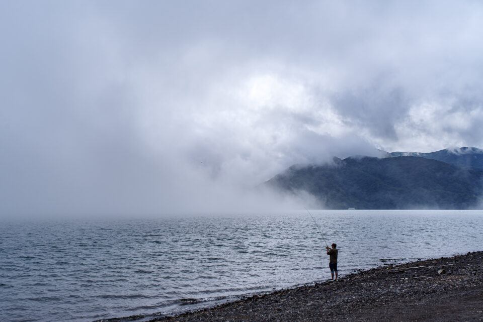 霧と中禅寺湖の釣り人