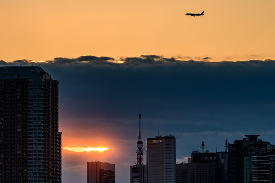 日没の東京タワー上空を飛ぶ飛行機