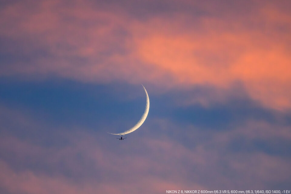 夕暮れ空に月と飛行機